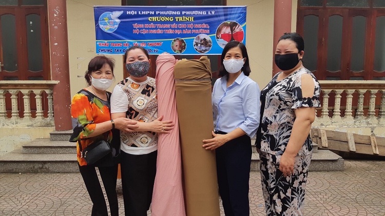 Chị Hoàng Quế Anh – Chủ tịch Hội LHPN phường Thượng Lý tiếp nhận vải của gia đình chị Trịnh Kim Mai