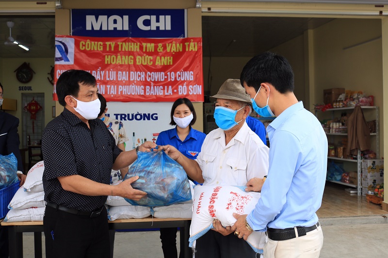 Đồng chí Cao Văn Bé – Chủ tịch UBND phường Bàng La cùng các nhà hảo tâm tặng gạo và thịt cho các gia đình có hoàn cảnh khó khăn do dịch Covid-19