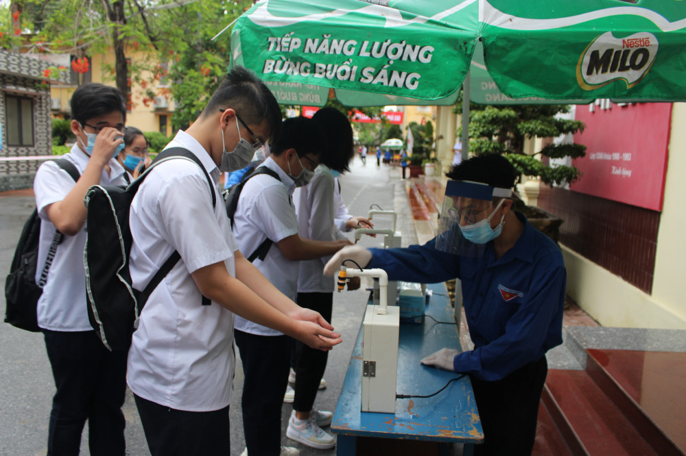 Các thí sinh sát khuẩn tay trước khi vào phòng thi
